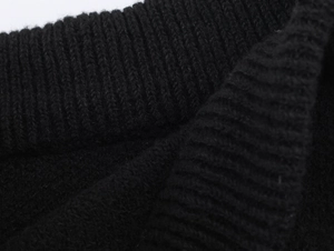 Detailed macro view of black ribbed knit fabric texture and high-quality stitching