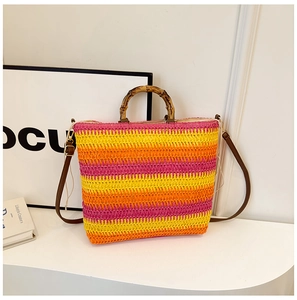 Detail view of woven straw tote with colorful stripes and vintage bamboo handles