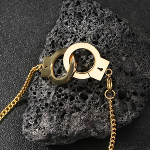Macro di un bracciale a manette in oro lucido su una pietra vulcanica nera ruvida