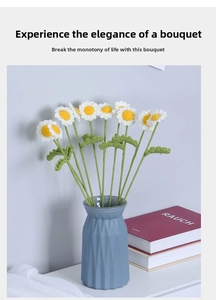 Detail view of handmade crochet daisy bouquet in a blue textured vase for home decor