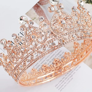 Close-up of rose gold bridal tiara with intricate hollow patterns and shimmering rhinestones