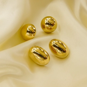 Minimalist polished gold stainless steel round and oval stud earrings on silk background