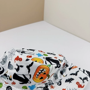 Detailed pattern of Halloween pumpkins, bats, and ghosts on a white cotton bucket hat