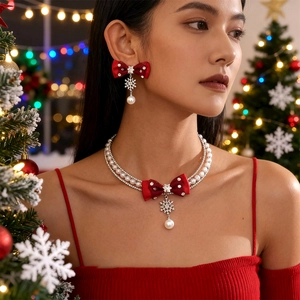 Macro view of Christmas bow necklace with snowflake pendant and white pearls detail