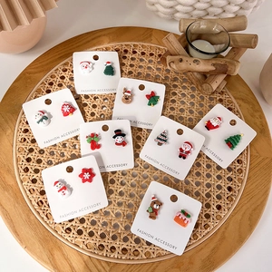 Christmas stud earrings set featuring Santa, snowman, and reindeer in a rustic tray