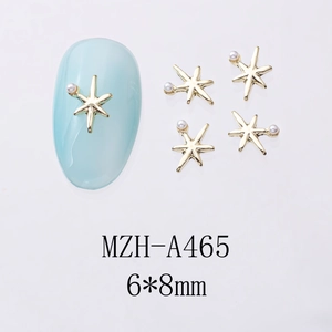 Vue macro détaillée des bijoux d'ongles étoile dorée 6x8mm avec perles MZH-A465
