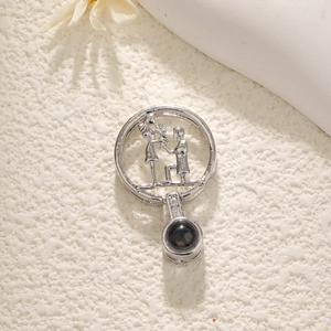 Macro shot of silver dreamcatcher necklace pendant with couple silhouette and projection stone