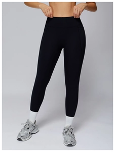 Detail shot of high-waisted black yoga pants with slimming compression lines and matte fabric
