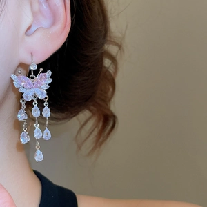 Detailed view of silver butterfly tassel earrings with pink and white zircon stones
