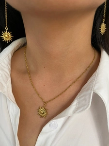 Close-up of model wearing 18K gold plated sunburst necklace and earrings jewelry set