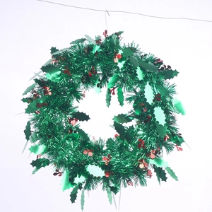 Green Christmas wreath with red berries and metallic glitter for holiday wall decoration