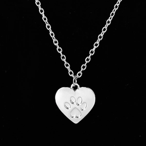 Collana minimalista in argento con ciondolo a cuore e zampa su sfondo nero