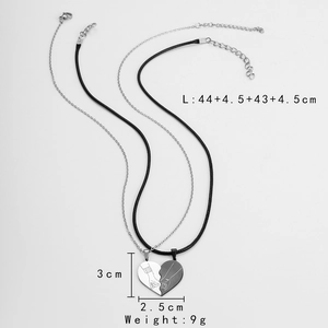 Macro detail of interlocking heart pendant with engraved hand-holding design and size info