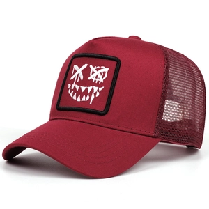 Detail of burgundy trucker hat featuring street style devil embroidery and breathable mesh