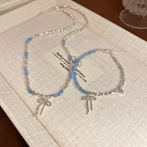 Silver bow pendant necklace with blue matte beads in a light luxury vintage style
