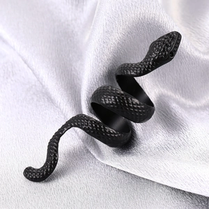 Macro shot of matte black snake spiral ring with detailed scales on silk background
