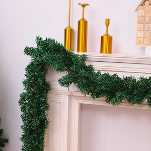 Close-up of dense green Christmas garland with pine needles on a festive fireplace mantel