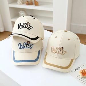 Close-up of funny dinosaur embroidery and letters on three cream cotton baseball caps