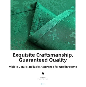 Detailed close-up of dark green Christmas tablecloth with elegant snowflake jacquard texture