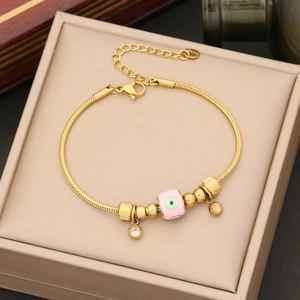 Armband aus Edelstahl in Gold mit rosa Evil-Eye-Perle und funkelnden Zirkonia-Anhängern