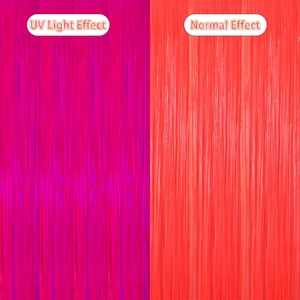 Neon tinsel curtain showing glowing purple effect under UV light versus normal orange light