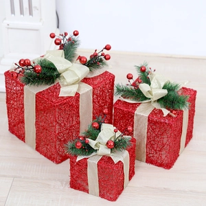 Three-piece red ironwork Christmas gift boxes with gold bows and pine needle accents