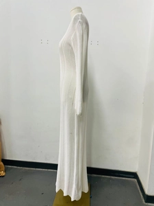 Detailed view of white knit hollow-out texture on elegant long-sleeved V-neck dress
