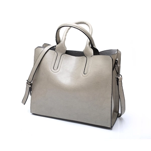 Detailed view of light gray faux leather tote with detachable strap and smooth finish