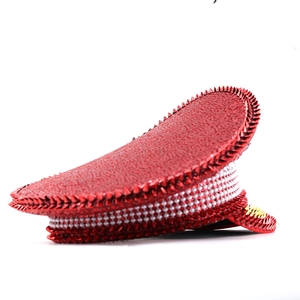 Detailed view of red sequins and punk spike rivets on festive captain hat with rhinestones