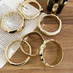 Collection de bracelets géométriques dorés avec des designs carrés lisses et texturés ondulés
