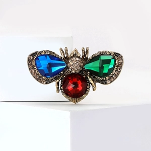 Macro detail of bee brooch with colorful pear-shaped gems and sparkling rhinestones