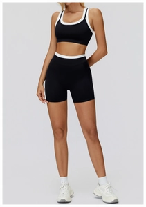 Detail of high-waisted ribbed yoga shorts and sports bra with white contrast trim