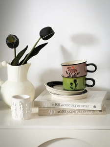 Close-up of vintage ceramic floral coffee cup set with hand-painted tulip patterns