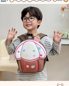 Detail of cute cupcake-shaped hardshell backpack with strawberry decor on a child