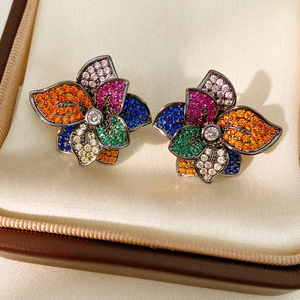 Close-up of vintage flower earrings with colorful pavé zircons in a luxury jewelry box
