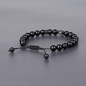 Close-up of adjustable leopard head bracelet with polished black beads and woven cord
