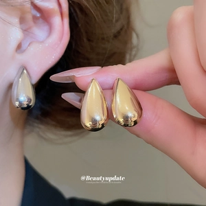 Polished gold metal teardrop earrings set with sleek metallic finish for women