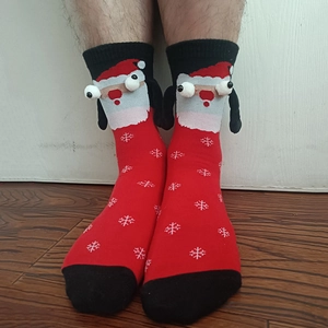 Detail of red Christmas socks with magnetic hands and 3D Santa Claus eyes decoration
