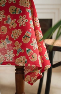 Detail of Christmas tablecloth made of red linen fabric with gingerbread man and tree prints