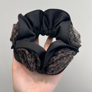 Detailed shot of double-layered black and leopard print satin organza scrunchie