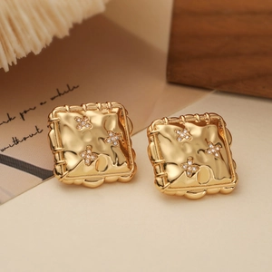 Macro view of 18K gold plated square earrings with hammered texture and tiny zircons