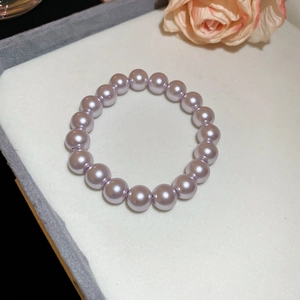 Detailed close-up of lavender pearl beaded bracelet on white jewelry display case