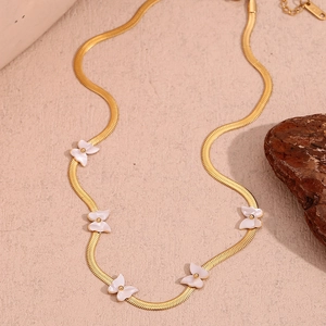 Detail of 18K gold-plated blade chain featuring white shell butterfly pendants
