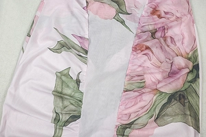 Detail of pink floral print dress showing side ruching and delicate woven fabric texture