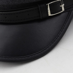 Gros plan détaillé de la visière en cuir noir et feutre de laine avec boucle en argent