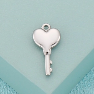 Macro shot of polished silver heart-shaped key pendant for DIY stainless steel jewelry