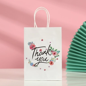 Detail of white paper gift bag with colorful flowers, thank you script and rope handles