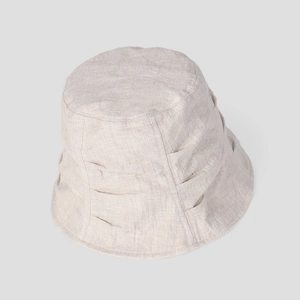 Detailed macro view of the pleated texture and natural linen fabric on a beige sun hat