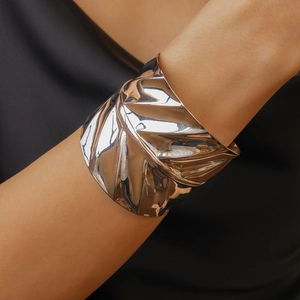 Detail of silver leaf-shaped cuff bracelet with mirror-polished metallic texture