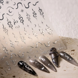 Silver metallic snake nail stickers with star and moon designs on dark base